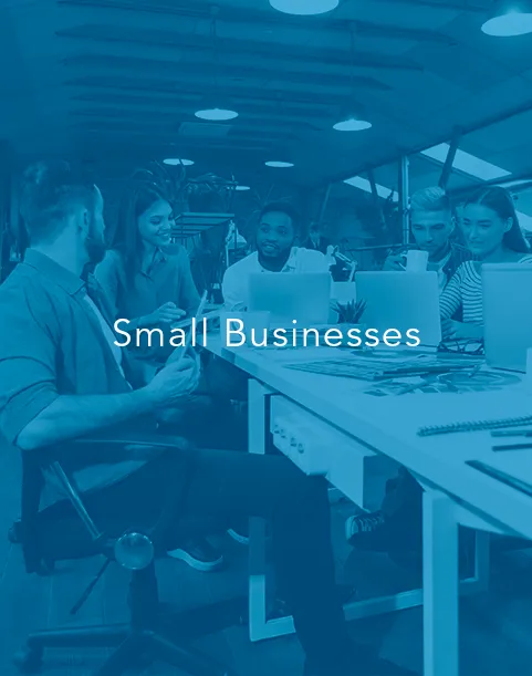 Infinity Tech Consulting supports small business professionals collaborating with laptops in modern coworking office environment